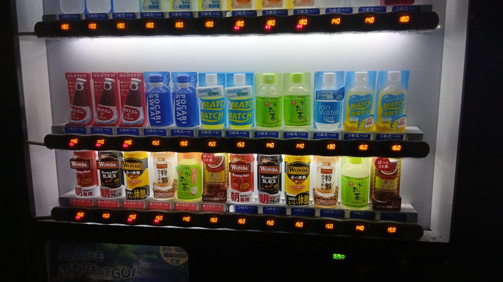 Minuman hangat dari vending machine yang dipegang di malam hari setelah perjalanan, memberikan rasa hangat di udara dingin sepulang dari Kusatsu Onsen